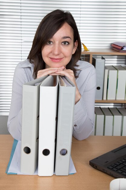 Thoughtful business woman with documents in her workplace