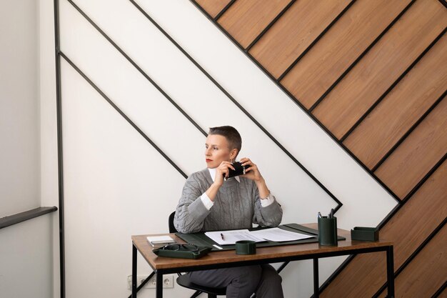 Thoughtful business woman at the workplace at the window in the office