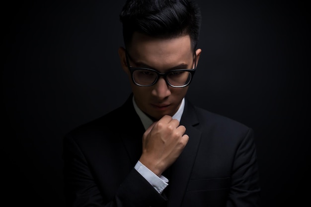 thoughtful businessman against black background