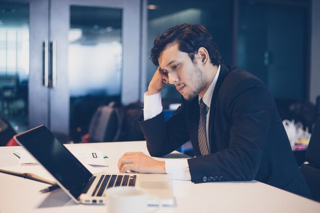 Thoughtful businessman sitting at desk in office