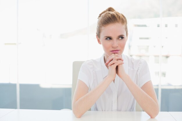 Thoughtful businesswoman sitting at office desk