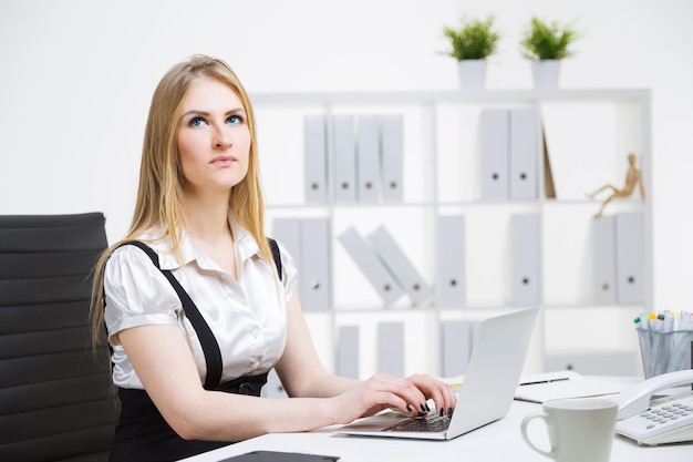 Thoughtful businesswoman typing