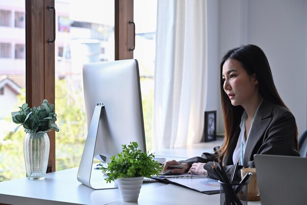 Thoughtful businesswoman working in bright office.