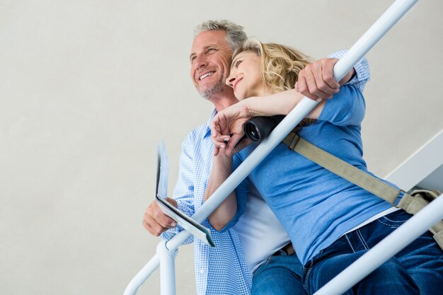 Thoughtful couple by railing at home