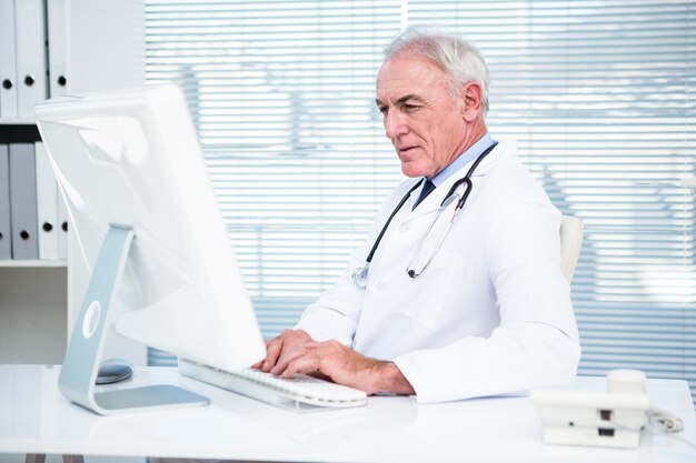 Thoughtful doctor working on computer