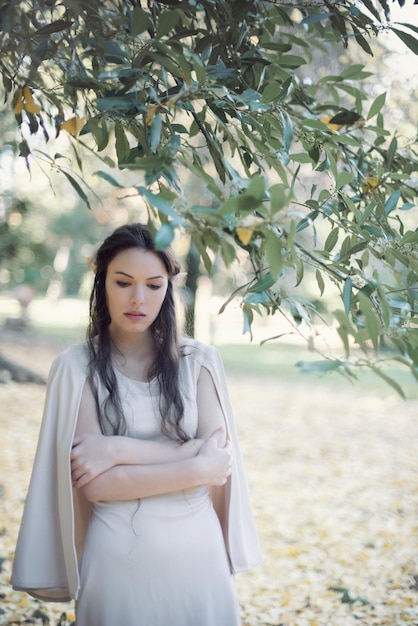 Photo thoughtful fairy elf young woman with arms crossed standing at park