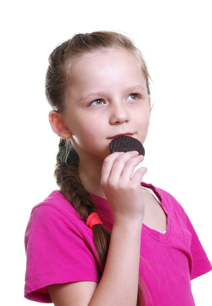 Photo thoughtful girl eating chocolate biscuit against white background