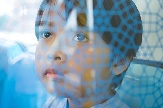 Photo thoughtful girl looking away through glass window