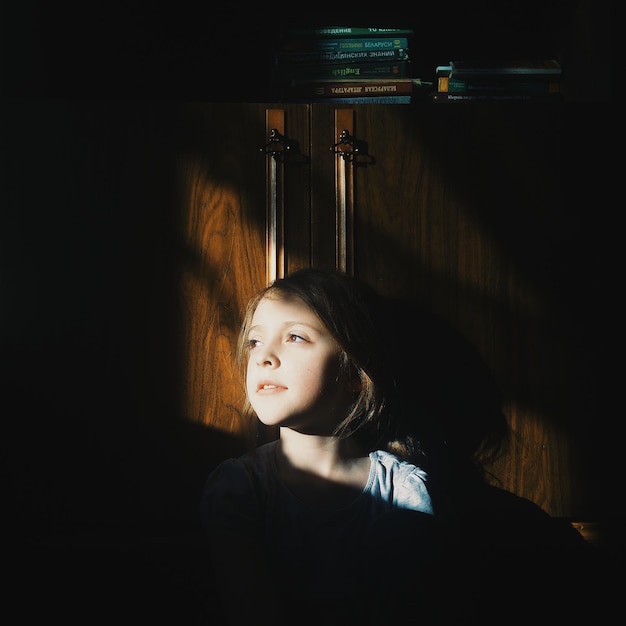 Photo thoughtful girl sitting in darkroom