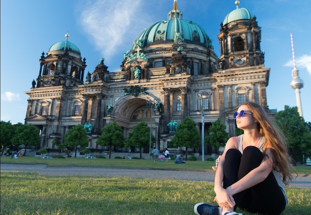 Thoughtful girl tourist sitting in germany near berlin cathedral. berlin cathedral view in germany with sitting girl. building tomorrow world today. travel around europe. life is awesome.