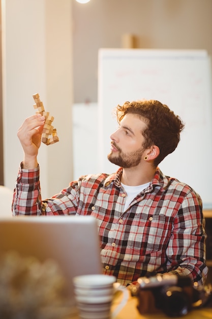 Photo thoughtful graphic designer looking at wooden block