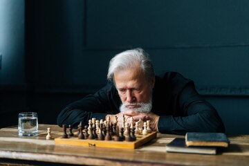 Senior man thinking about his next move in a game of chess Stock Photo by  dmytros9