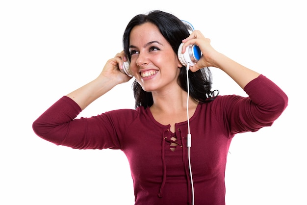 Thoughtful happy Spanish woman smiling while listening to music