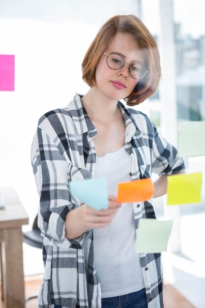 thoughtful hipster woman, sitting at her desk reading notes