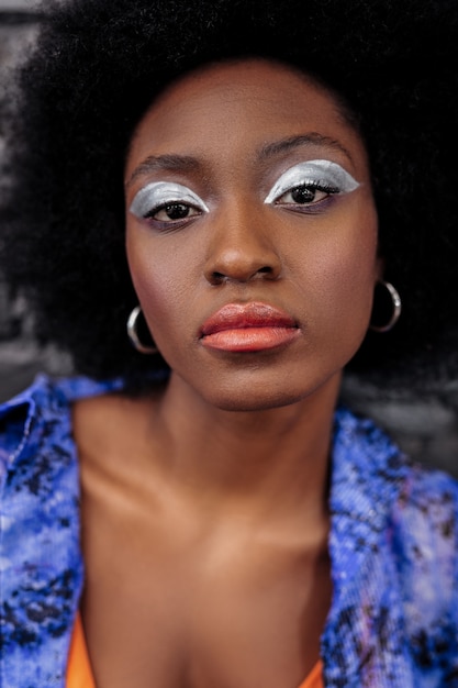 Thoughtful lady. Dark-haired beautiful model with bright makeup looking thoughtful while posing