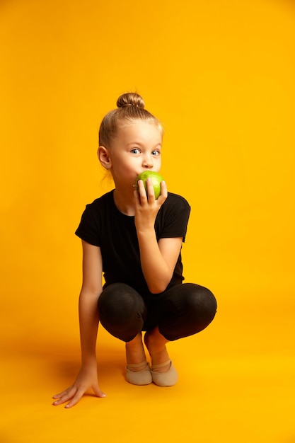 Thoughtful little dancer with apple during break