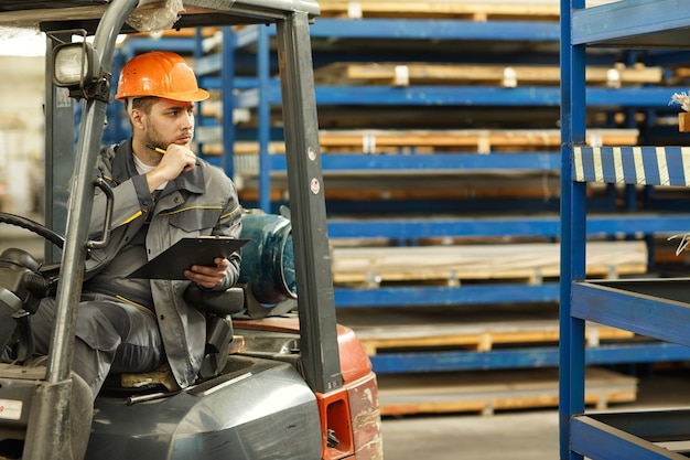 Thoughtful male engineer wearing protective uniform and a hardhat sitting