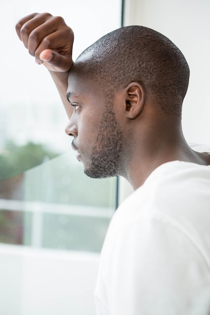 Thoughtful man looking out of window in morning