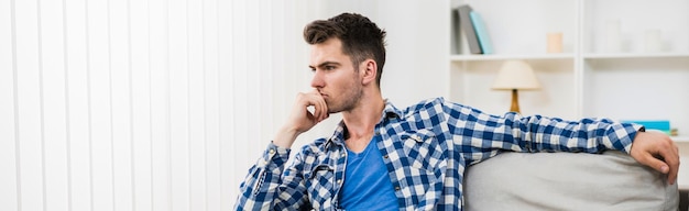 The thoughtful man sit on the sofa