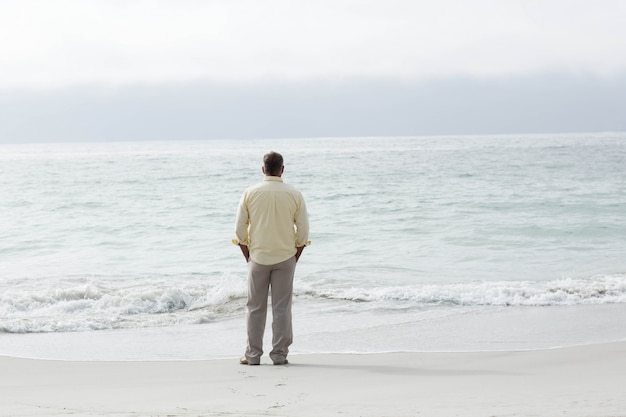 Photo thoughtful man standing by the sea