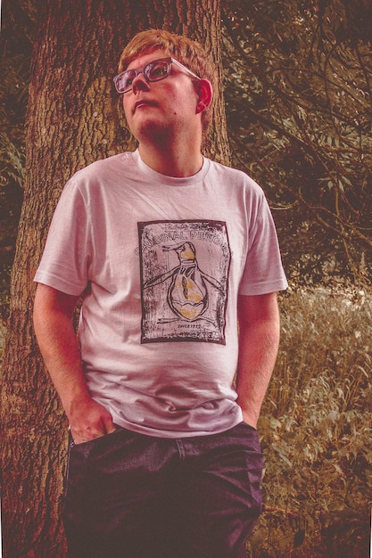 Thoughtful man standing on grassy field