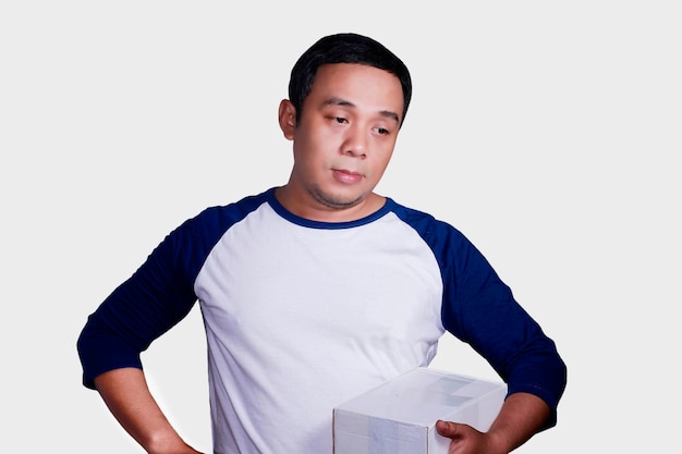 Photo thoughtful man with box standing against white background