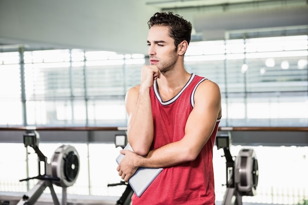 Thoughtful man with chin on fist in the gym