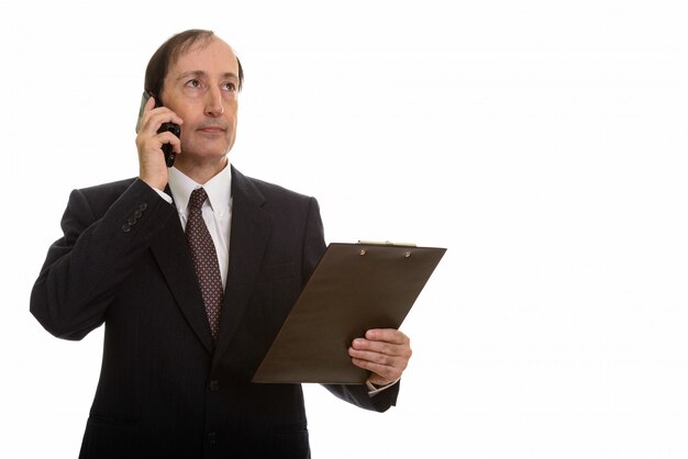 вдумчивый зрелый бизнесмен разговаривает по мобильному телефону
