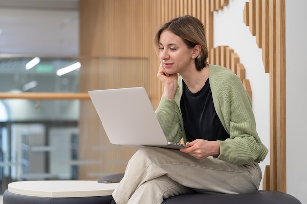 공동 작업 공간에서 온라인으로 작업하는 노트북을 사용하는 사려 깊은 중년 여성 프리랜서 작가