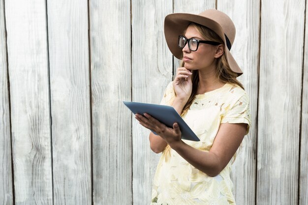 Thoughtful pretty women with glasses holding tablet 