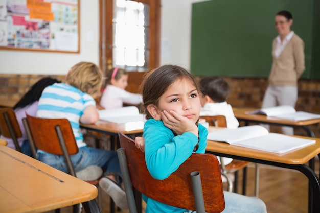 Thoughtful pupil sitting at her desk