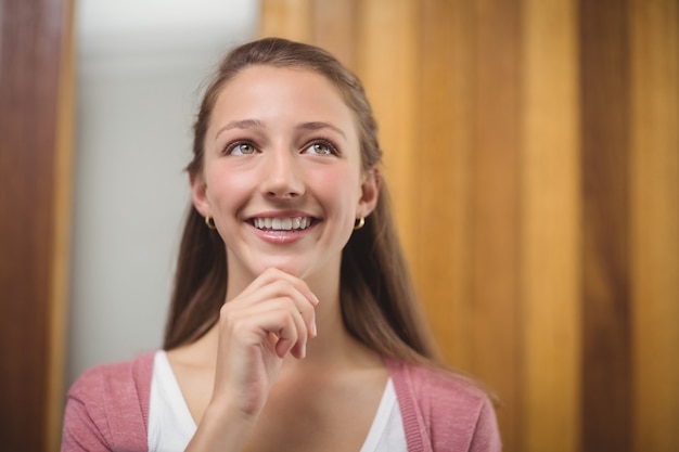 Thoughtful schoolgirl with hand on chin