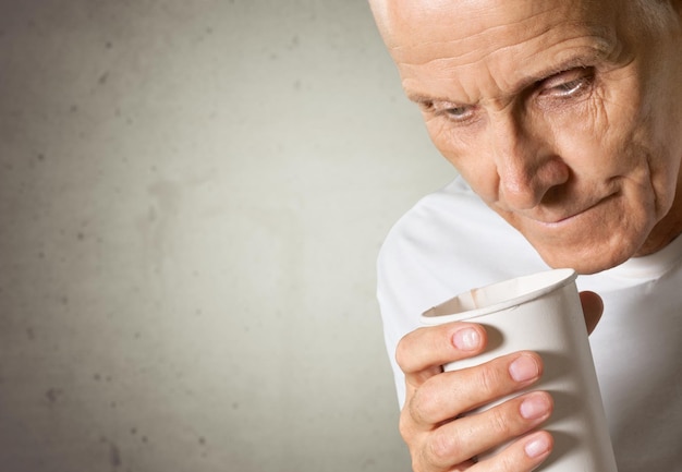 Photo thoughtful senior man with cup at home