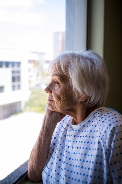 Thoughtful senior patient looking through window