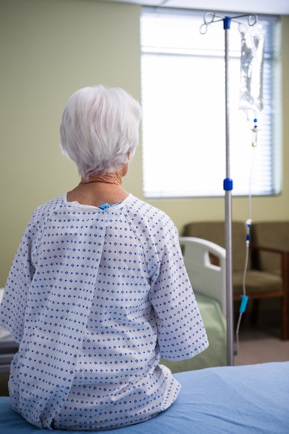 Thoughtful senior patient sitting at hospital