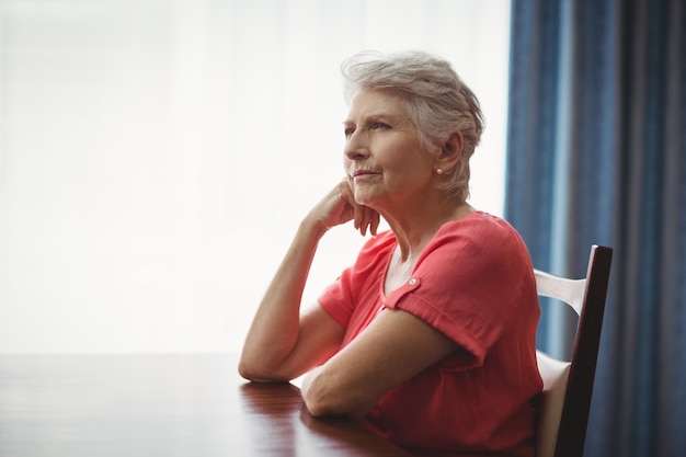 Thoughtful senior woman sitting at a table