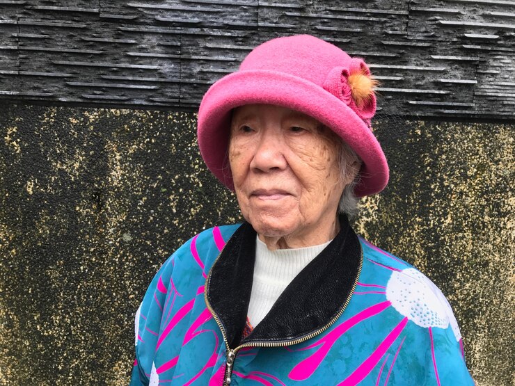 Photo 벽에 붙어 서 있는 사려 깊은 노인 여자