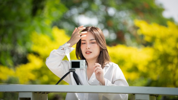 Thoughtful smile Happy woman videocalling online or meeting online working with a laptop in a park