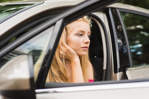 Thoughtful tired woman in car