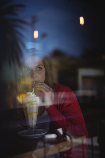 Foto donna premurosa che mangia milkshake