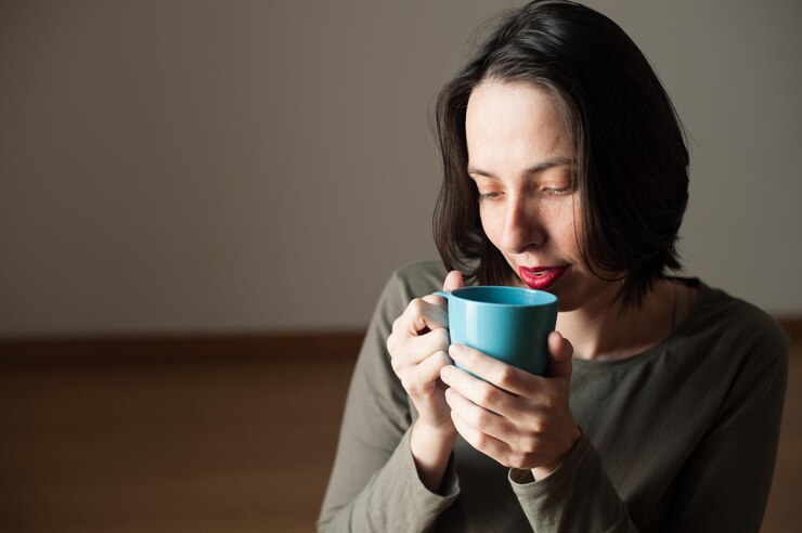 Photo 家でコーヒーカップを握っている思慮深い女性