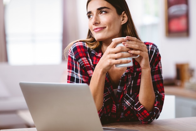 Thoughtful woman holding coffee mug 