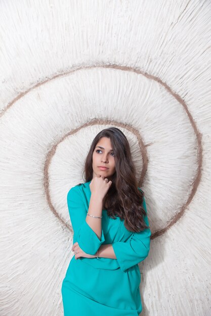 Thoughtful woman leaning on wall with spiral