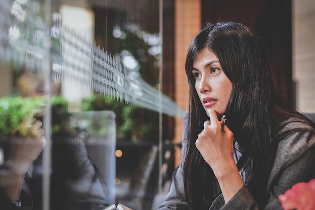 Foto donna premurosa che guarda attraverso la finestra