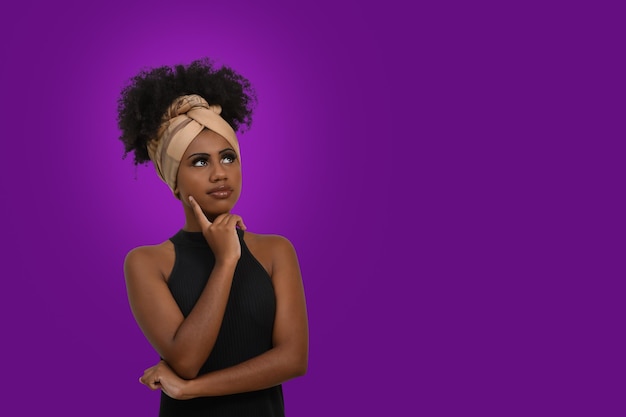 Thoughtful woman positioned on the left side of the image on purple background