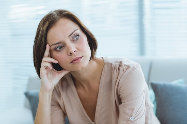 Thoughtful woman sitting at home