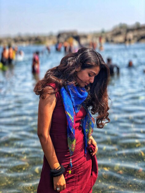 Photo thoughtful woman standing at beach