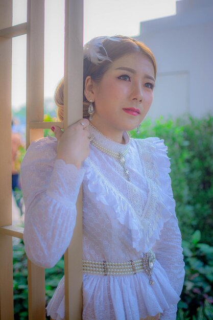 Thoughtful woman standing by metal grate