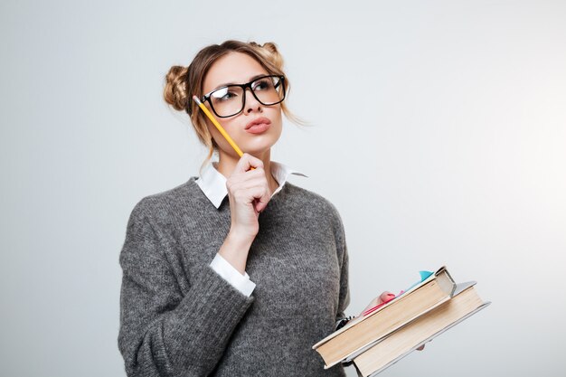 Thoughtful Woman in sweater and eyeglasses with books