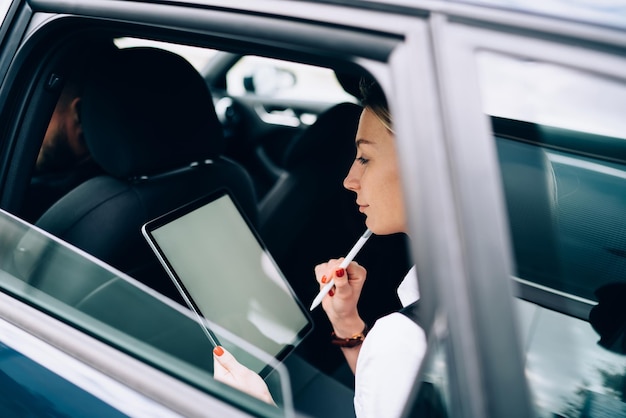 車内でタブレットを使用して思いやりのある女性